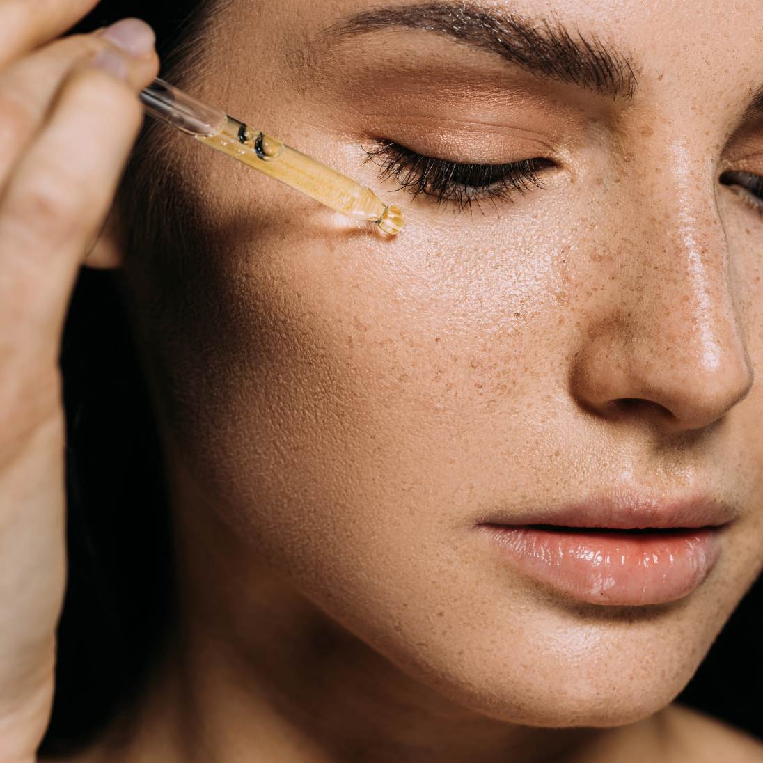 Woman applying eye serum